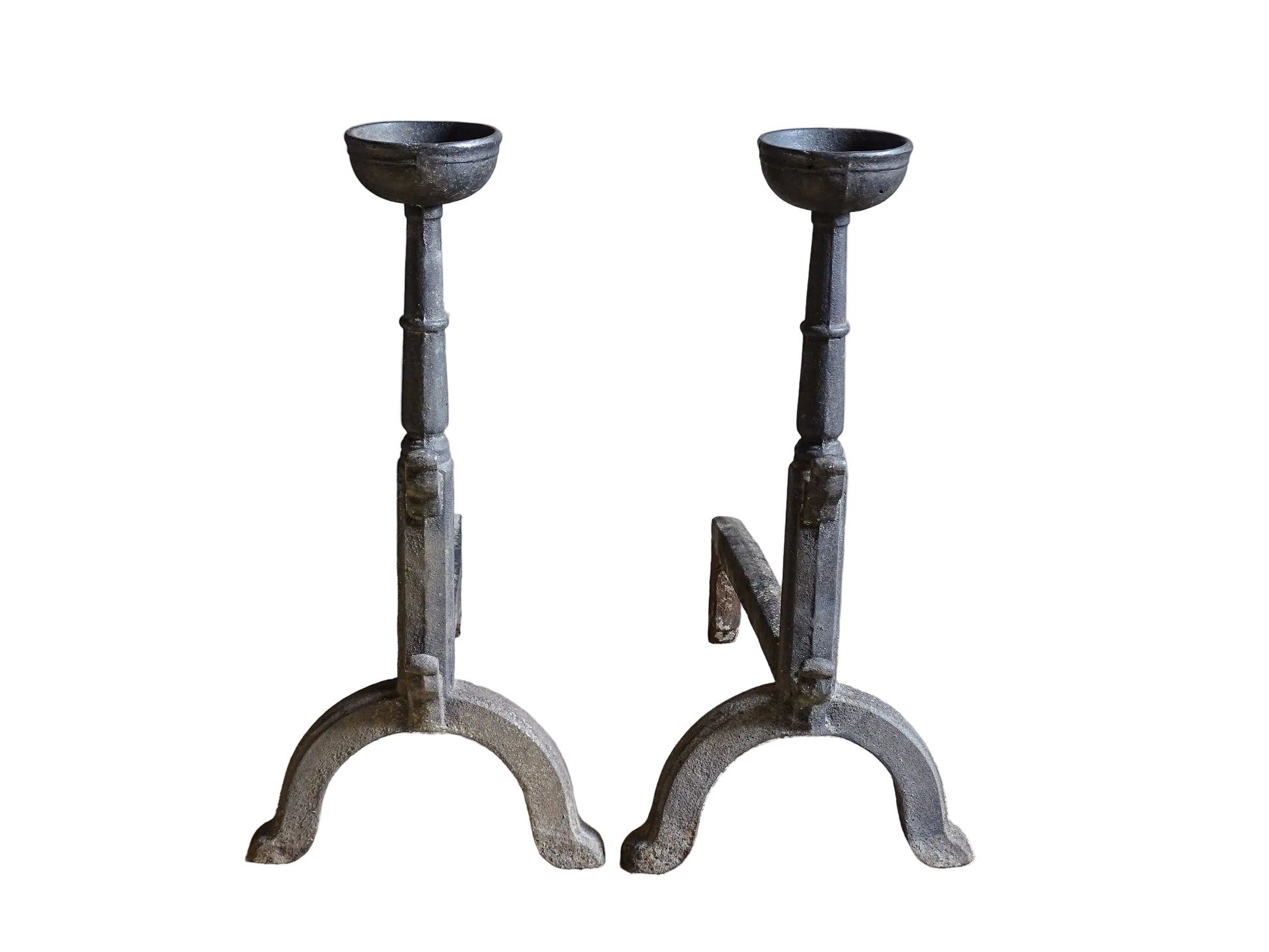 A  pair of French antique cast iron andirons or fire dogs, date to the 19th century. They are large and heavy and each have two spit hooks to the front and bowls to the top.