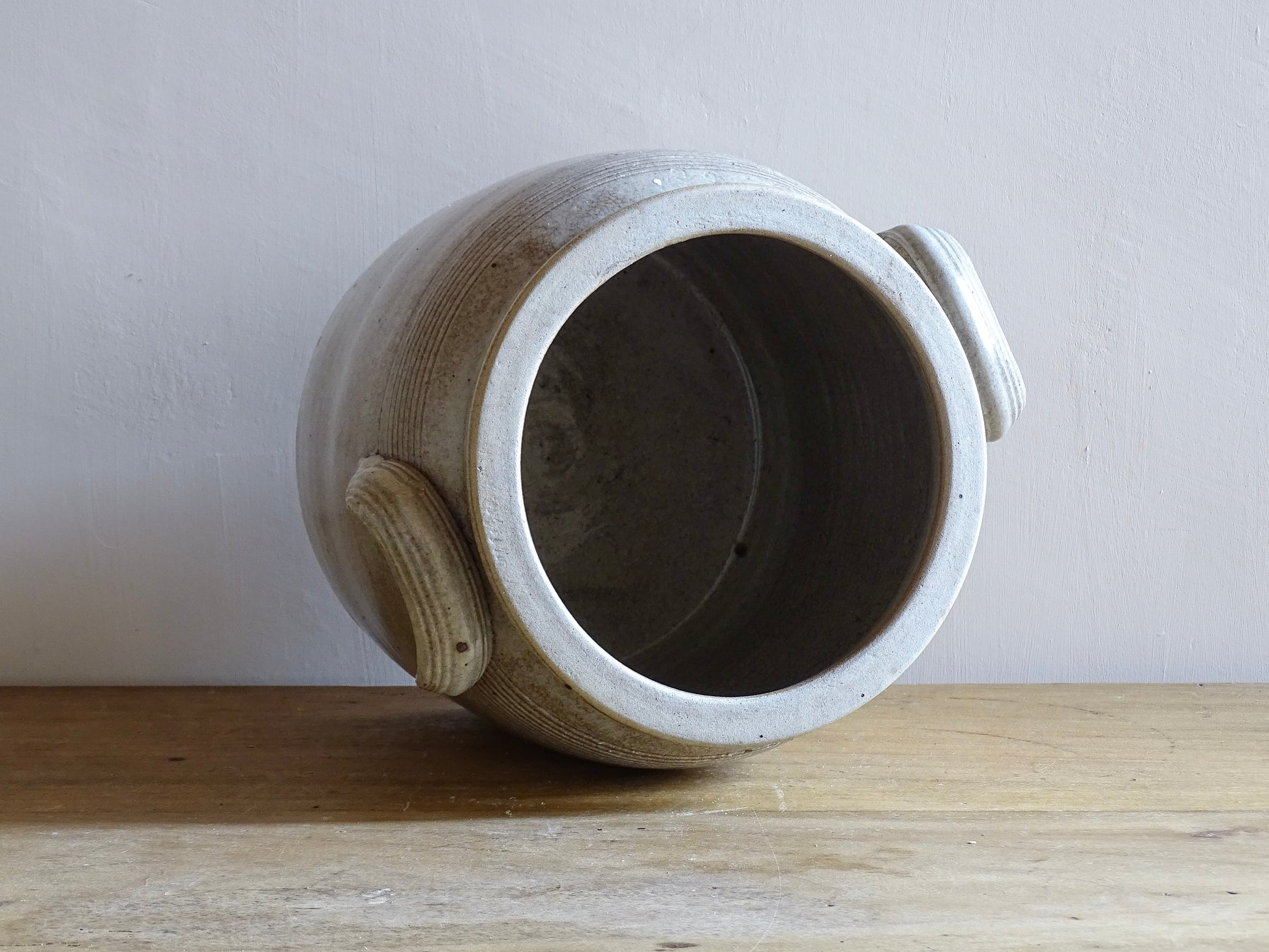 Large French antique stoneware confit pot with a grey beige glaze. This glazed pottery cache pot dates to the early 20th century and would look amazing as part of a rustic French farmhouse style home.