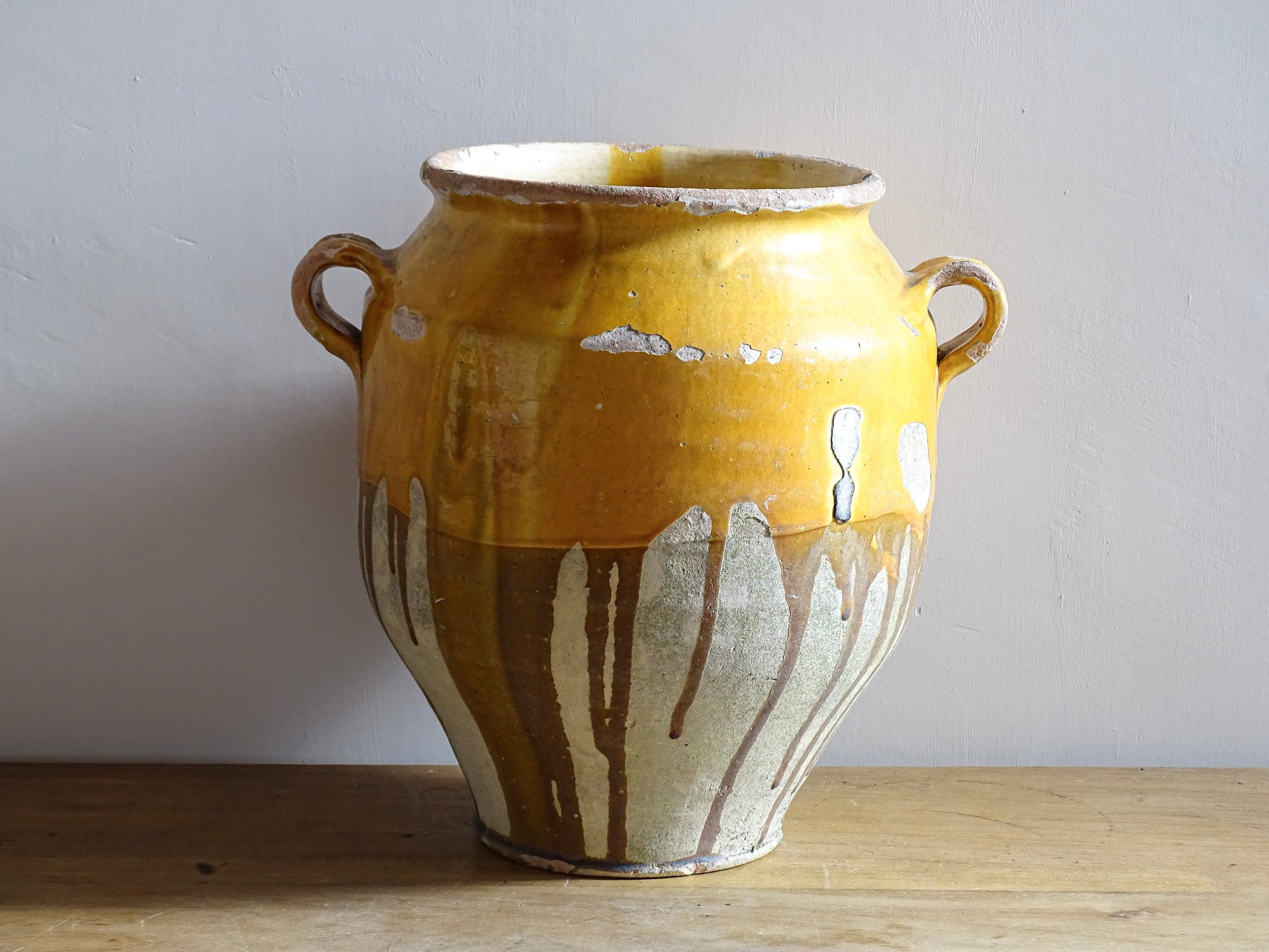 Large French antique confit pot with an ochre yellow glaze. These beautiful pots were originally used to preserve meats in the South of France. This confit jar would look beautiful placed on console table or kitchen counter, fill it with dried flowers or display with a collection of French pottery.
