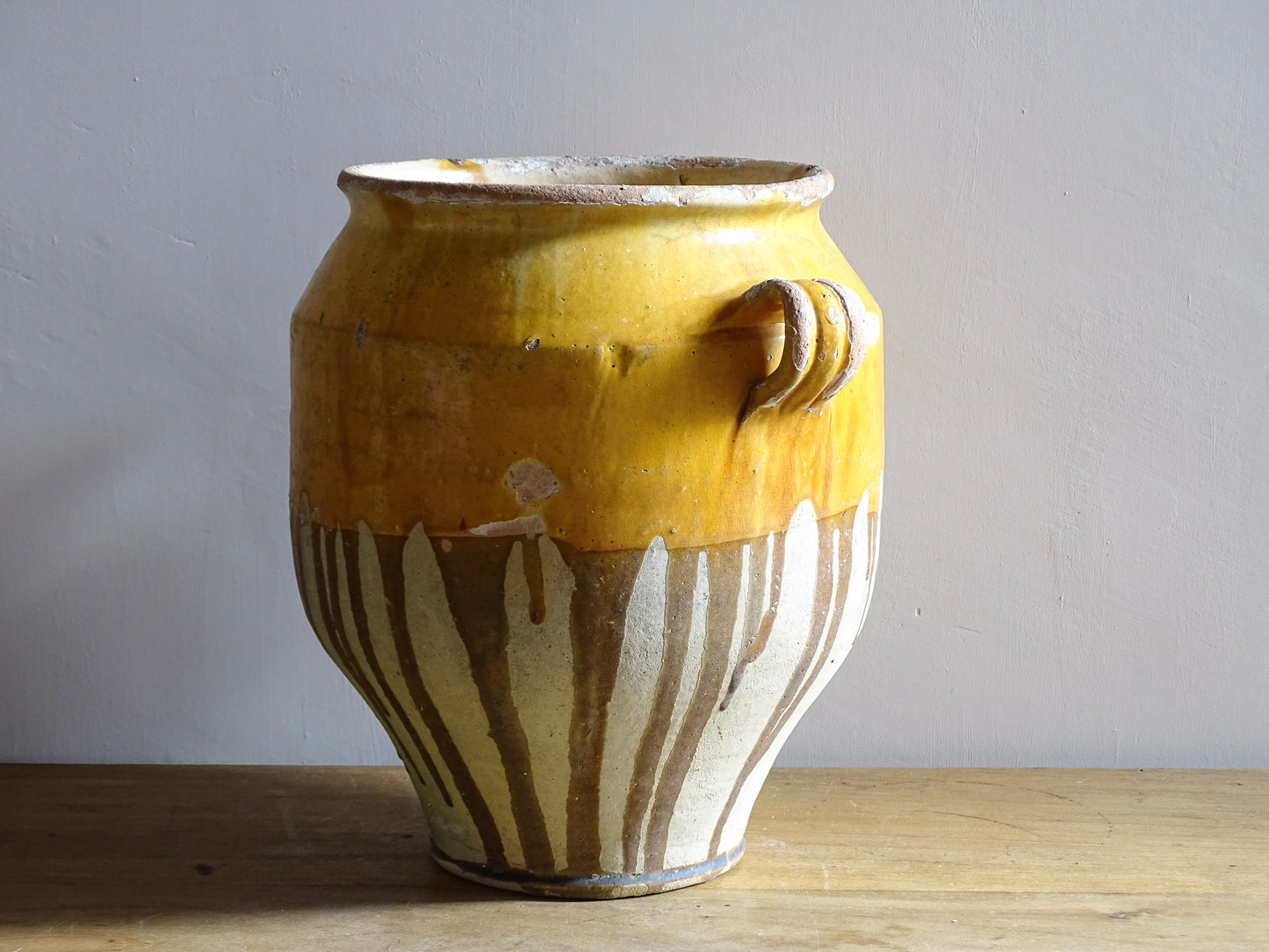 Large French antique confit pot with an ochre yellow glaze. These beautiful pots were originally used to preserve meats in the South of France. This confit jar would look beautiful placed on console table or kitchen counter, fill it with dried flowers or display with a collection of French pottery.