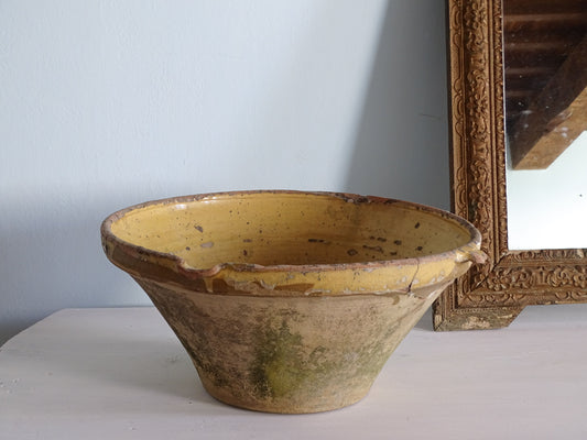 Large French antique tian bowl with a yellow glaze, pictured next to a gold mirror