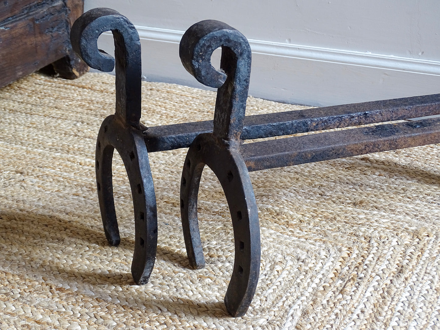  pair of French antique wrought iron andirons or fire dogs, date to the 19th century. They incorporate hand-forged horseshoes, with square-punched nail holes and substantial rear supports. A rustic, agricultural design with authentic forge marks throughout.