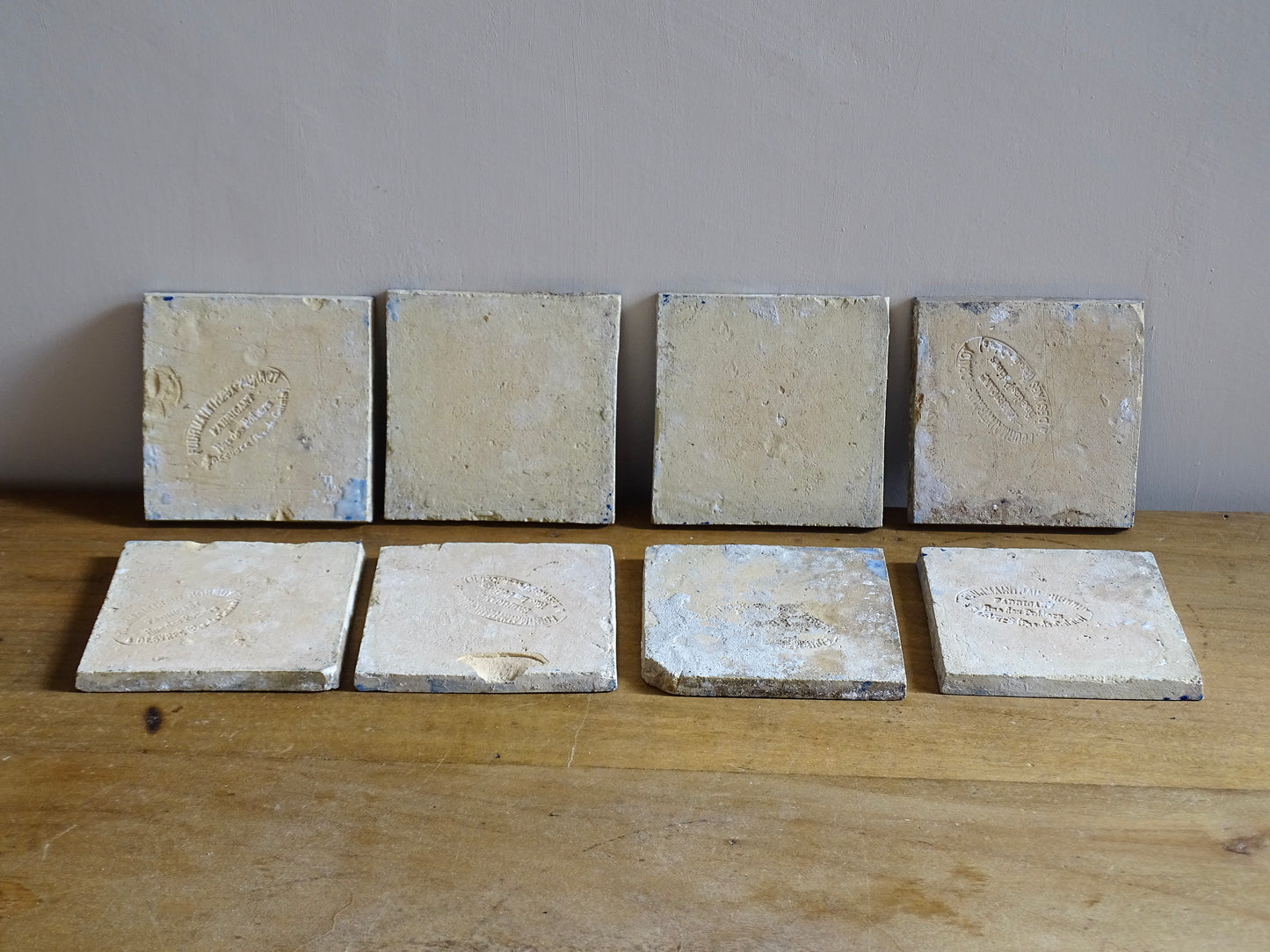 A set of eight French antique Desvres faience tiles in blue &amp; white. These transfer printed, earthenware tiles were manufactured in the late 1900's in Desvres, Northern France. Six of the tiles are back-stamped. They are beautifully transfer printed in cobalt blue. A floral sprig sits in the centre of the cartouche framing.