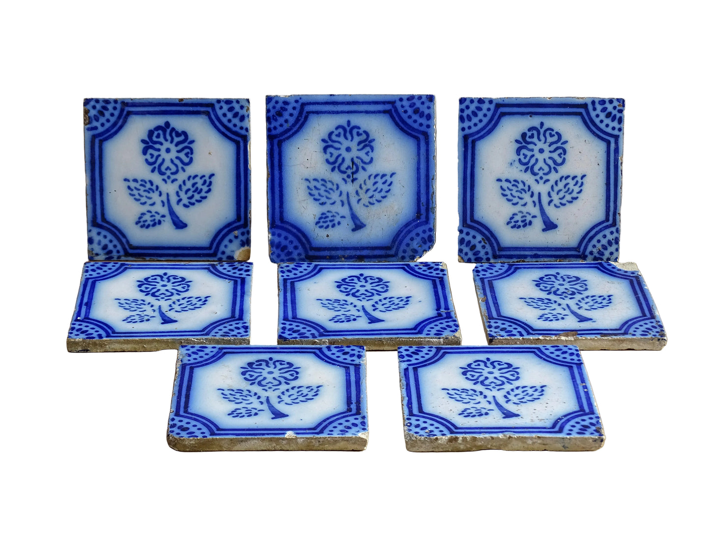 A set of eight French antique Desvres faience tiles in blue &amp; white. These transfer printed, earthenware tiles were manufactured in the late 1900's in Desvres, Northern France. Six of the tiles are back-stamped. They are beautifully transfer printed in cobalt blue. A floral sprig sits in the centre of the cartouche framing.