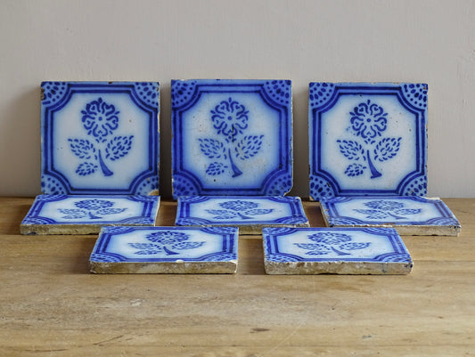 A set of eight French antique Desvres faience tiles in blue &amp; white. These transfer printed, earthenware tiles were manufactured in the late 1900's in Desvres, Northern France. Six of the tiles are back-stamped. They are beautifully transfer printed in cobalt blue. A floral sprig sits in the centre of the cartouche framing.