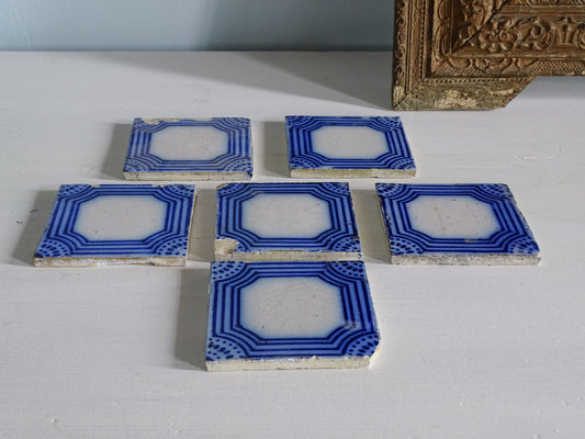 Set of six French antique earthenware tiles with blue and white geometric pattern by Desvres, pictured next to an ornate gold mirror