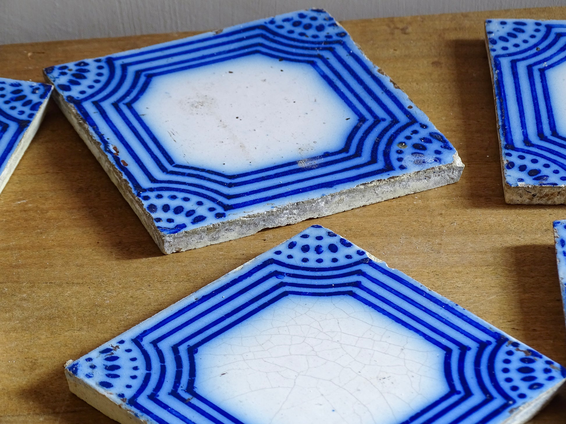 A set of six French antique Desvres faience tiles in blue &amp; white. These transfer printed, earthenware tiles were manufactured in the late 1900's in Desvres, Northern France. Five of the tiles are back-stamped. They are beautiful, transfer printed, architectural blue and white faience tiles with layered cobalt blue cartouche framing.