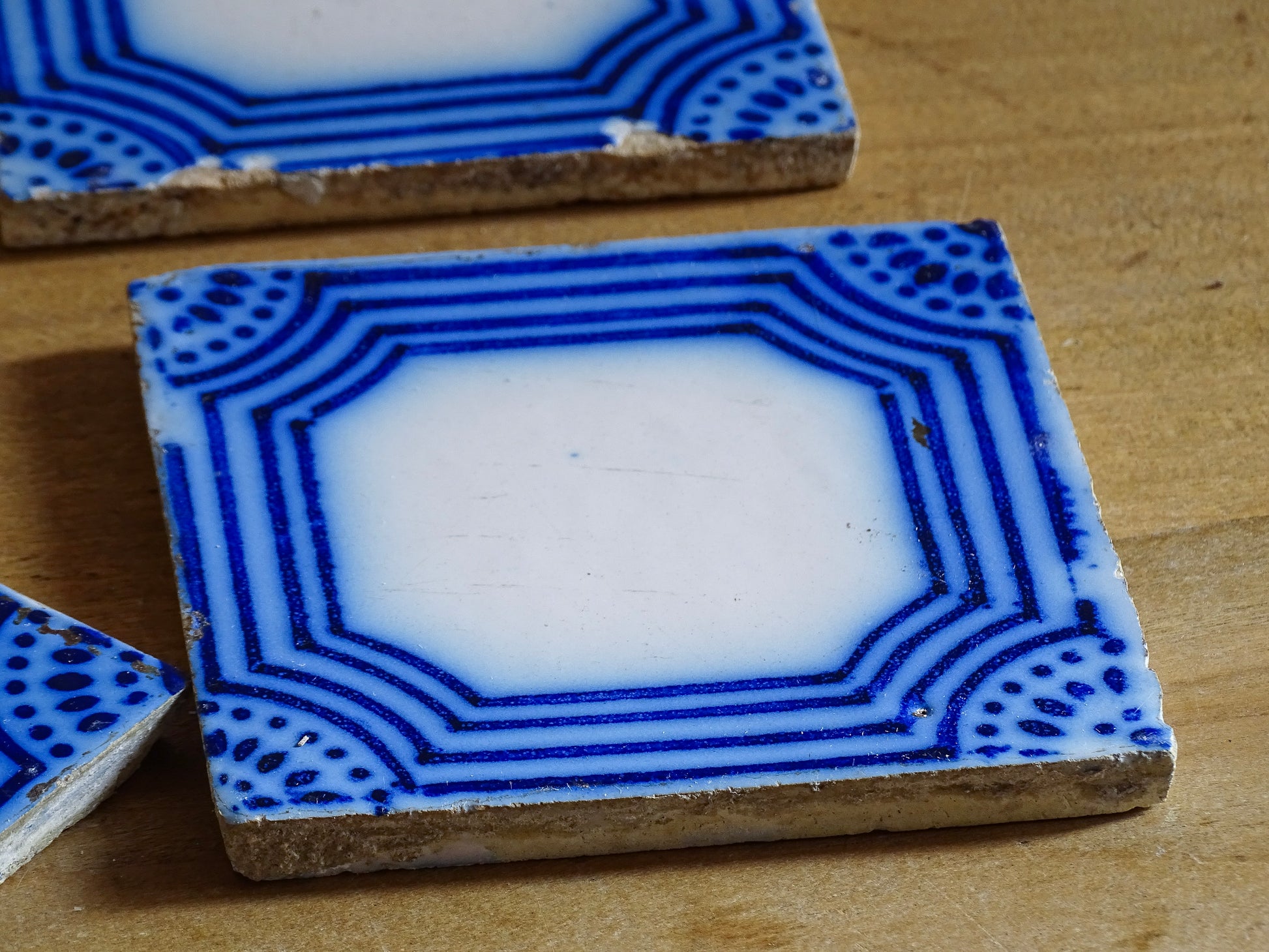 A set of six French antique Desvres faience tiles in blue &amp; white. These transfer printed, earthenware tiles were manufactured in the late 1900's in Desvres, Northern France. Five of the tiles are back-stamped. They are beautiful, transfer printed, architectural blue and white faience tiles with layered cobalt blue cartouche framing.