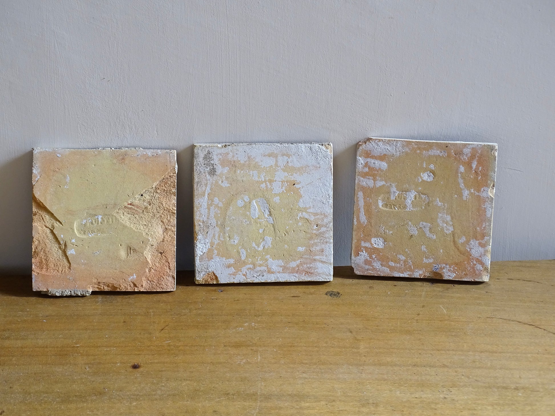 A set of three French antique Desvres faience tiles in blue &amp; white. These transfer printed, earthenware tiles were manufactured in the late 1900's in Desvres, Northern France. These antique tiles are back-stamped with the maker's mark. They are beautifully transfer printed in cobalt blue with a repeating Greek key motif and stylised wave border.