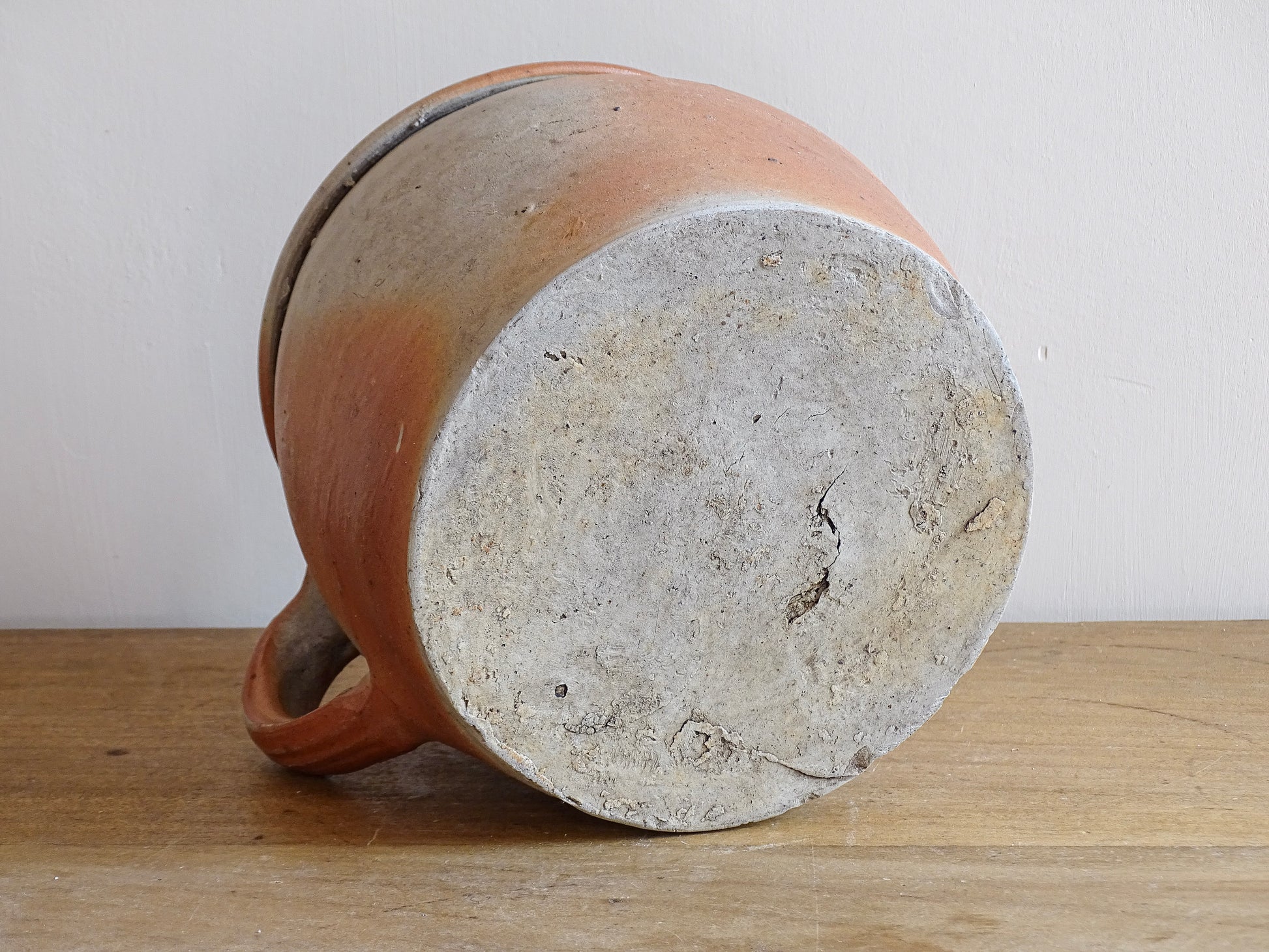 French antique stoneware jar with handle . This old confit pot with the colours of warm terracotta to pale hues is unglazed. It dates to the early 20th century. 