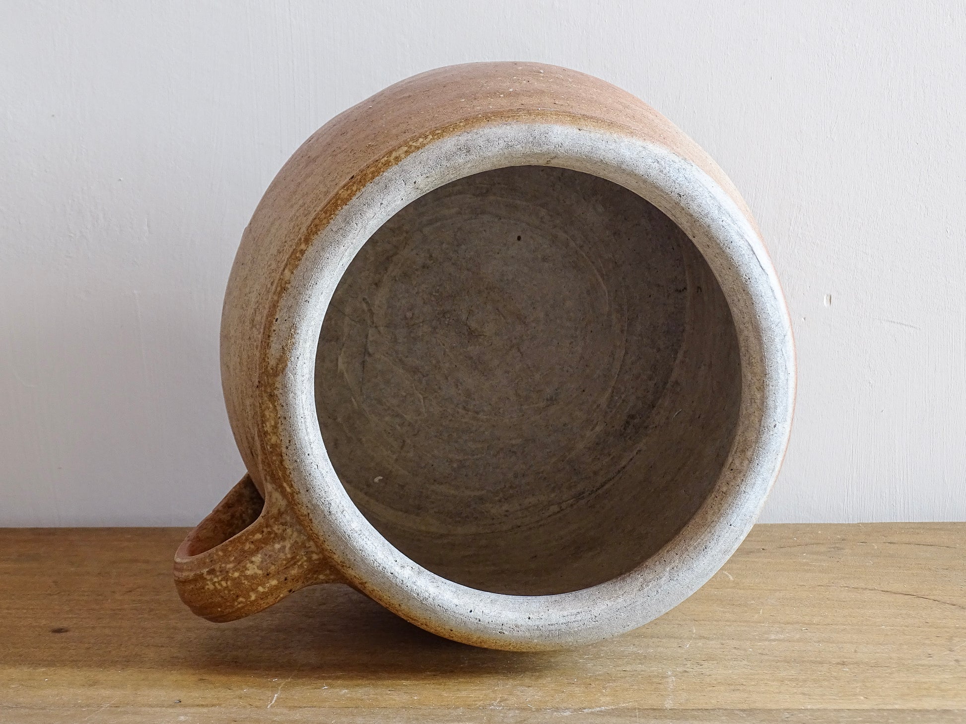 French antique stoneware jar with handle . This old confit pot with the colours of warm terracotta to pale hues is unglazed. It dates to the early 20th century. 