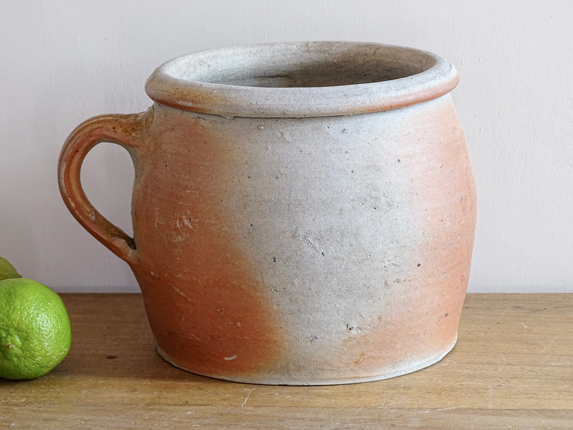 French antique stoneware jar with handle . This old confit pot with the colours of warm terracotta to pale hues is unglazed. It dates to the early 20th century. 