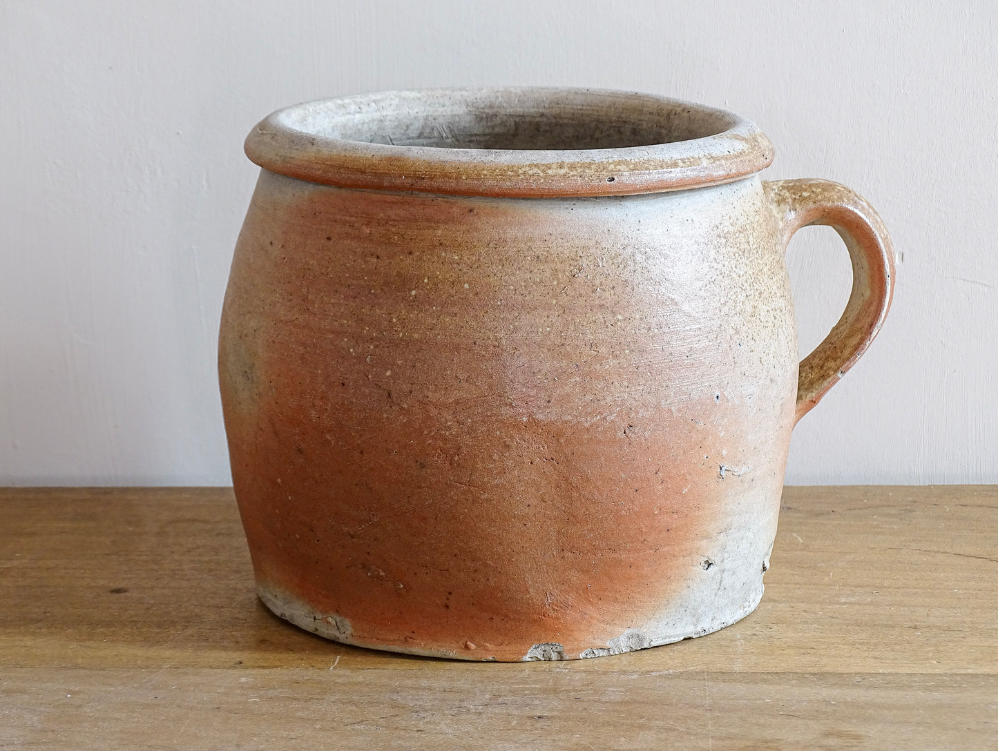 French antique stoneware jar with handle . This old confit pot with the colours of warm terracotta to pale hues is unglazed. It dates to the early 20th century. 