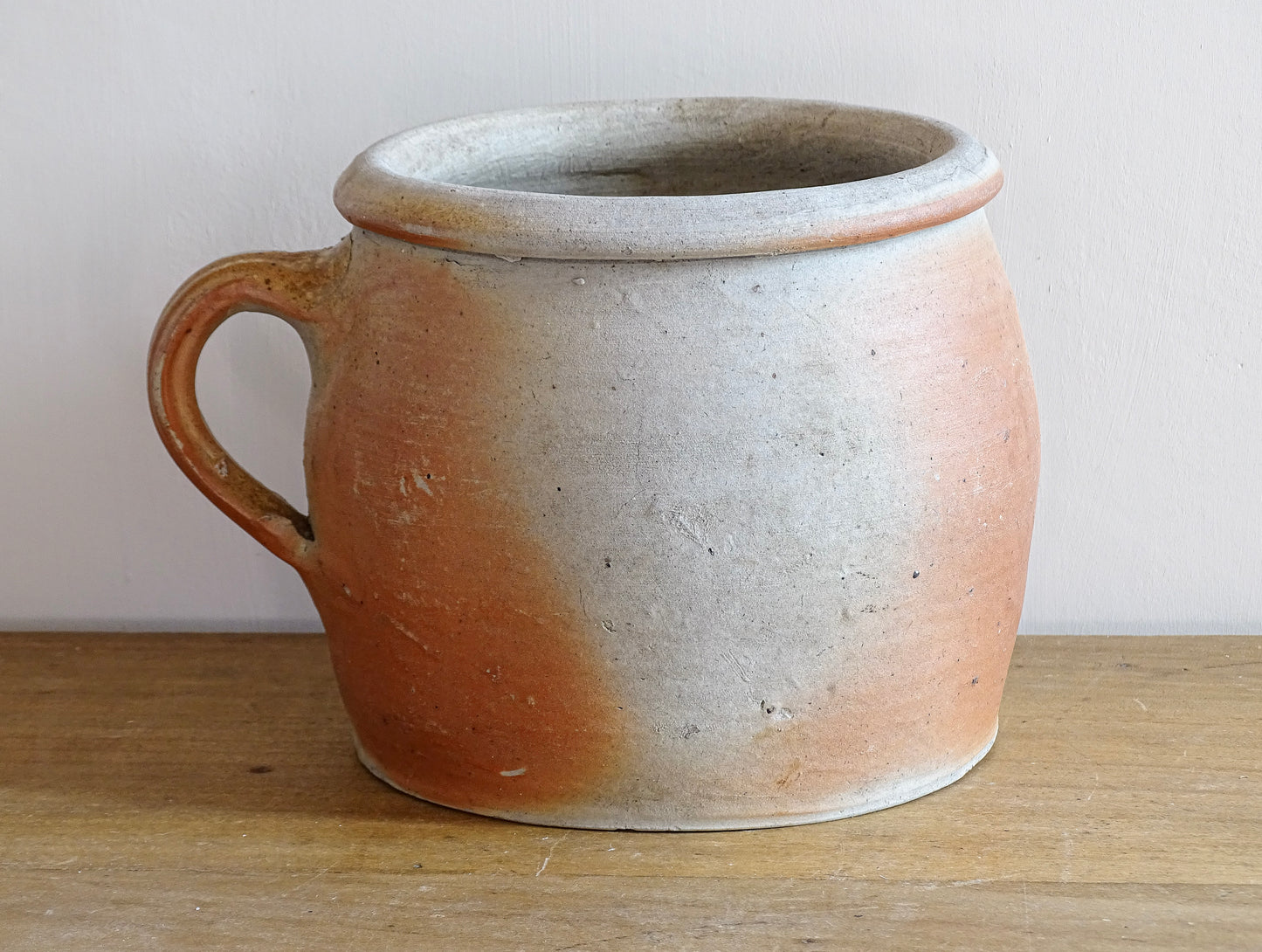 French antique stoneware jar with handle . This old confit pot with the colours of warm terracotta to pale hues is unglazed. It dates to the early 20th century. 
