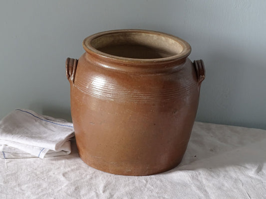 French antique stoneware pot with brown glaze, pictured with antique linen