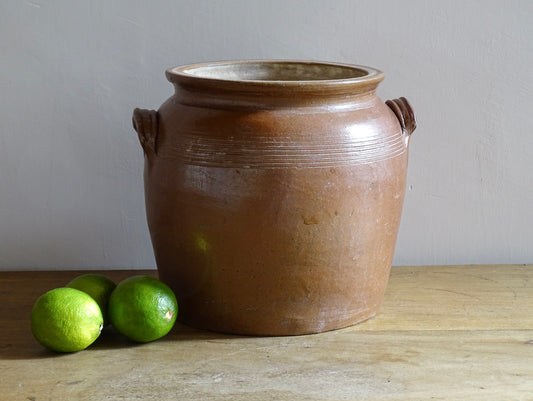 A French antique stoneware confit pot with a brown glaze. This is a salt glazed pottery cache pot. It dates to the early 20th century and would look amazing as part of a rustic French farmhouse style home. 