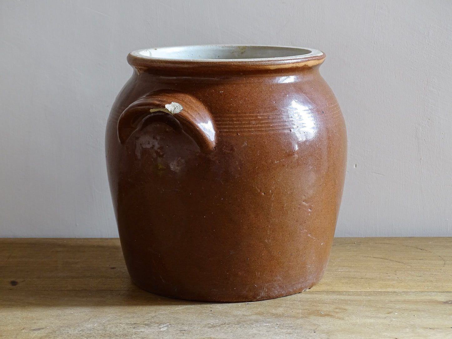 French antique stoneware preserving jar with a brown glaze. This pottery cache pot dates to the early 20th century and has a high gloss glaze. 