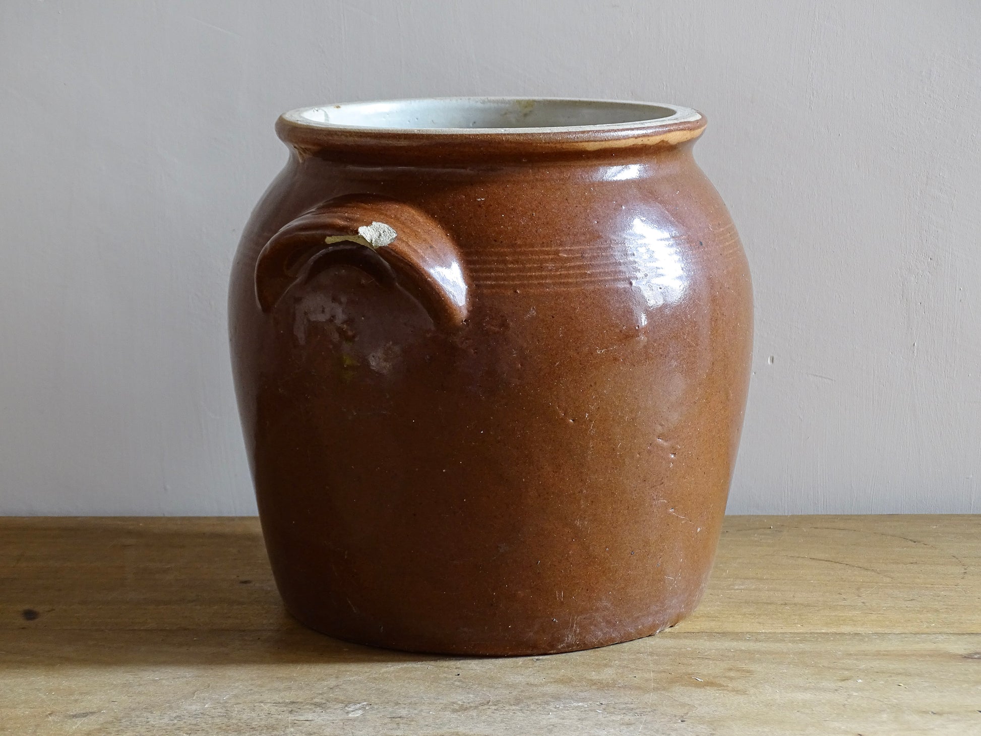 French antique stoneware preserving jar with a brown glaze. This pottery cache pot dates to the early 20th century and has a high gloss glaze. 