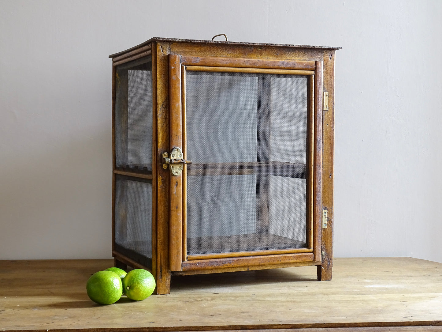 A French antique garde manger or countertop pantry cabinet. Circa 1920. This antique wooden garde manger with wire mesh panels on all sides was traditionally used for storing cheese, fruit, and baked goods while allowing air to circulate.