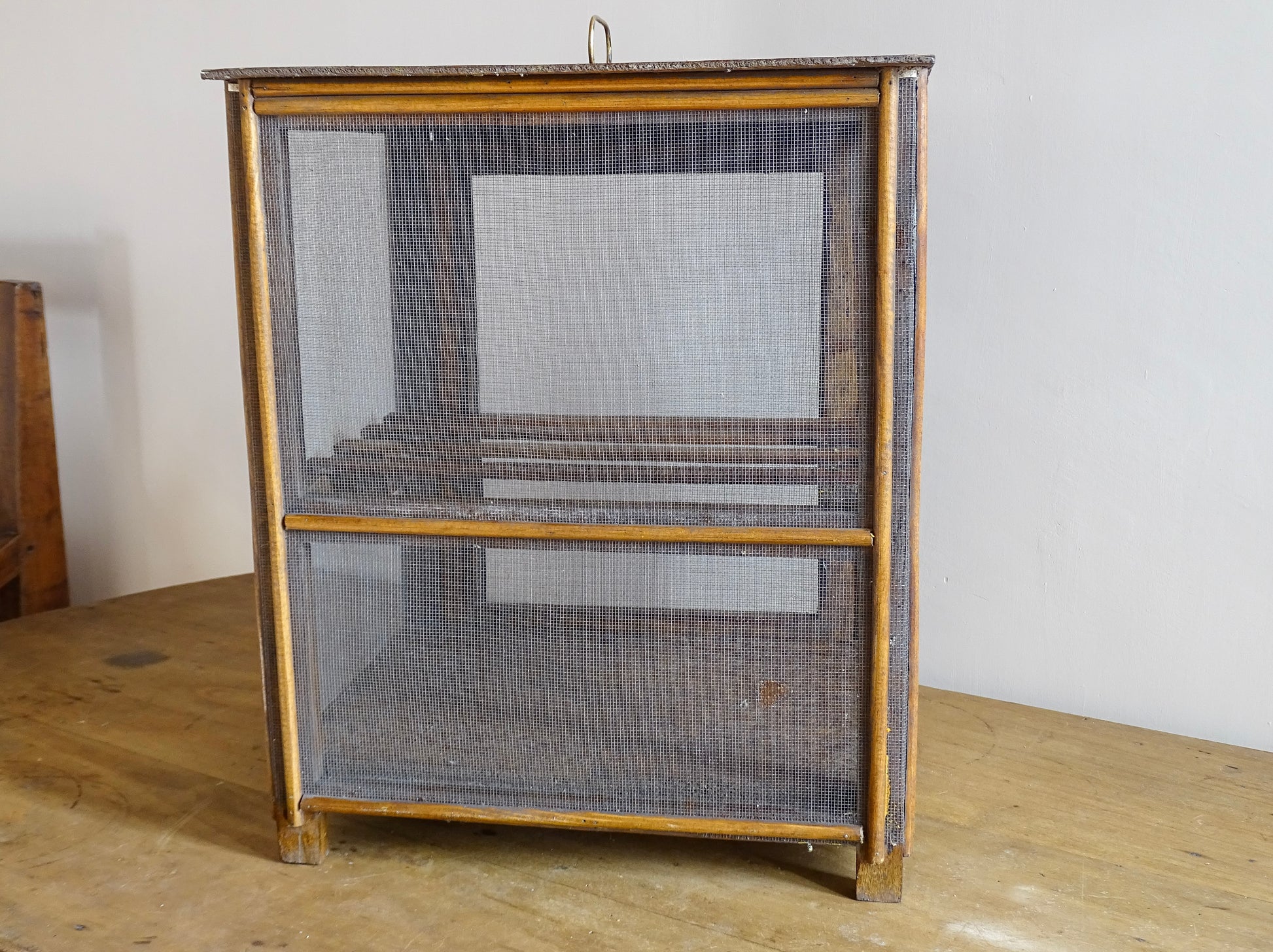 A French antique garde manger or countertop pantry cabinet. Circa 1920. This antique wooden garde manger with wire mesh panels on all sides was traditionally used for storing cheese, fruit, and baked goods while allowing air to circulate.