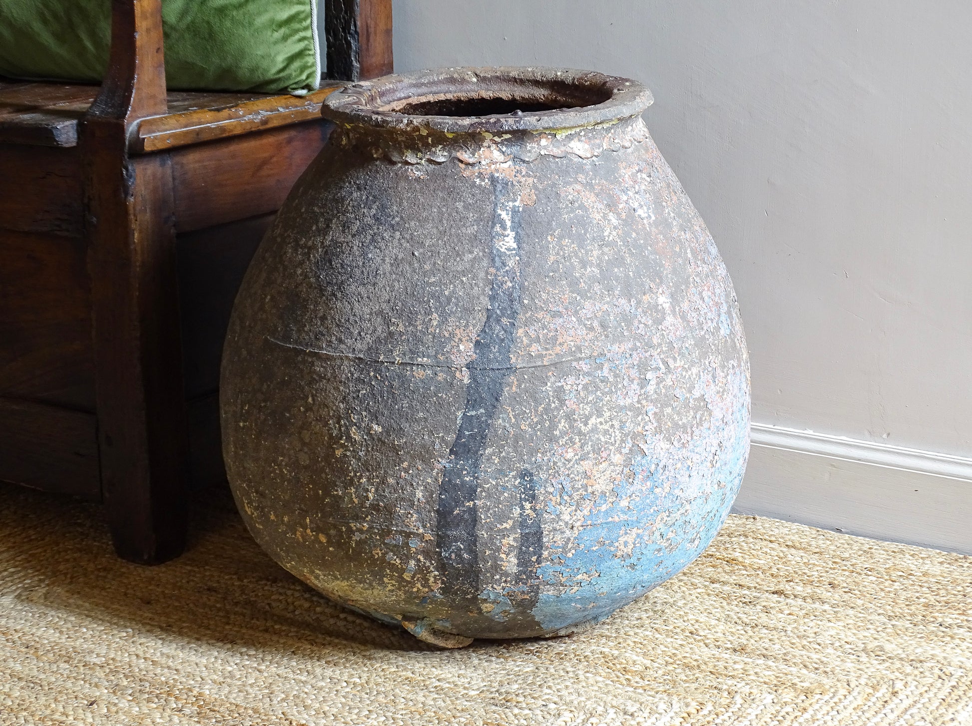 A large, early 19th century French antique terracotta pot, known as a ponne (salting pot), sourced in the Bordeaux region and likely Charentais in origin. This example has a beautifully rounded, generous form with a rolled rim. The surface is particularly special, showing layers of time, wear and historic pigment. Traces of faded blue and earthy tones remain across the body, creating a richly textured patina. 