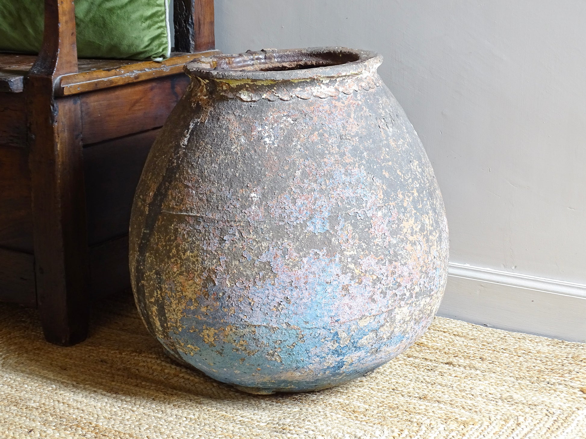 A large, early 19th century French antique terracotta pot, known as a ponne (salting pot), sourced in the Bordeaux region and likely Charentais in origin. This example has a beautifully rounded, generous form with a rolled rim. The surface is particularly special, showing layers of time, wear and historic pigment. Traces of faded blue and earthy tones remain across the body, creating a richly textured patina. 