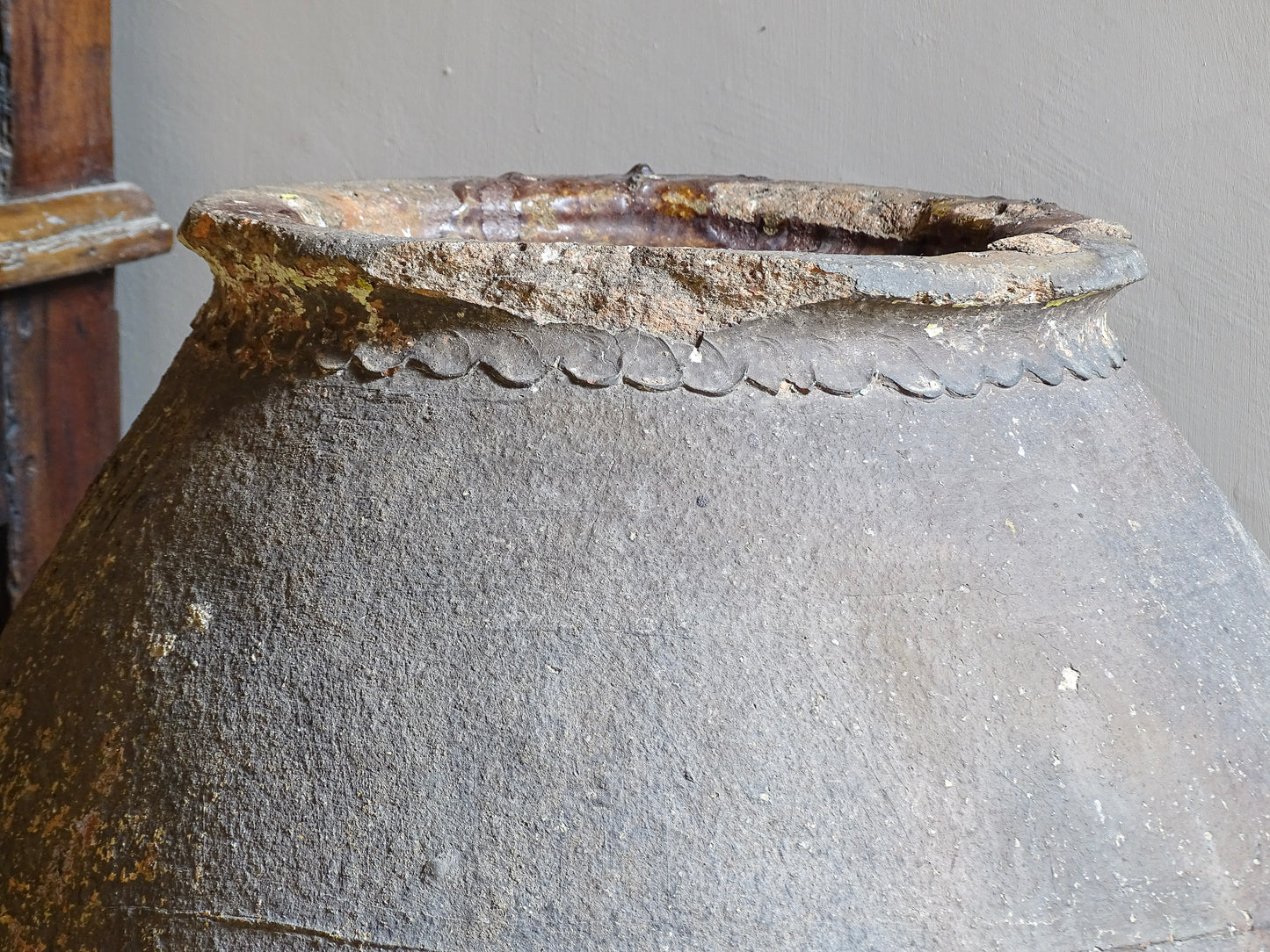 A large, early 19th century French antique terracotta pot, known as a ponne (salting pot), sourced in the Bordeaux region and likely Charentais in origin. This example has a beautifully rounded, generous form with a rolled rim. The surface is particularly special, showing layers of time, wear and historic pigment. Traces of faded blue and earthy tones remain across the body, creating a richly textured patina. 