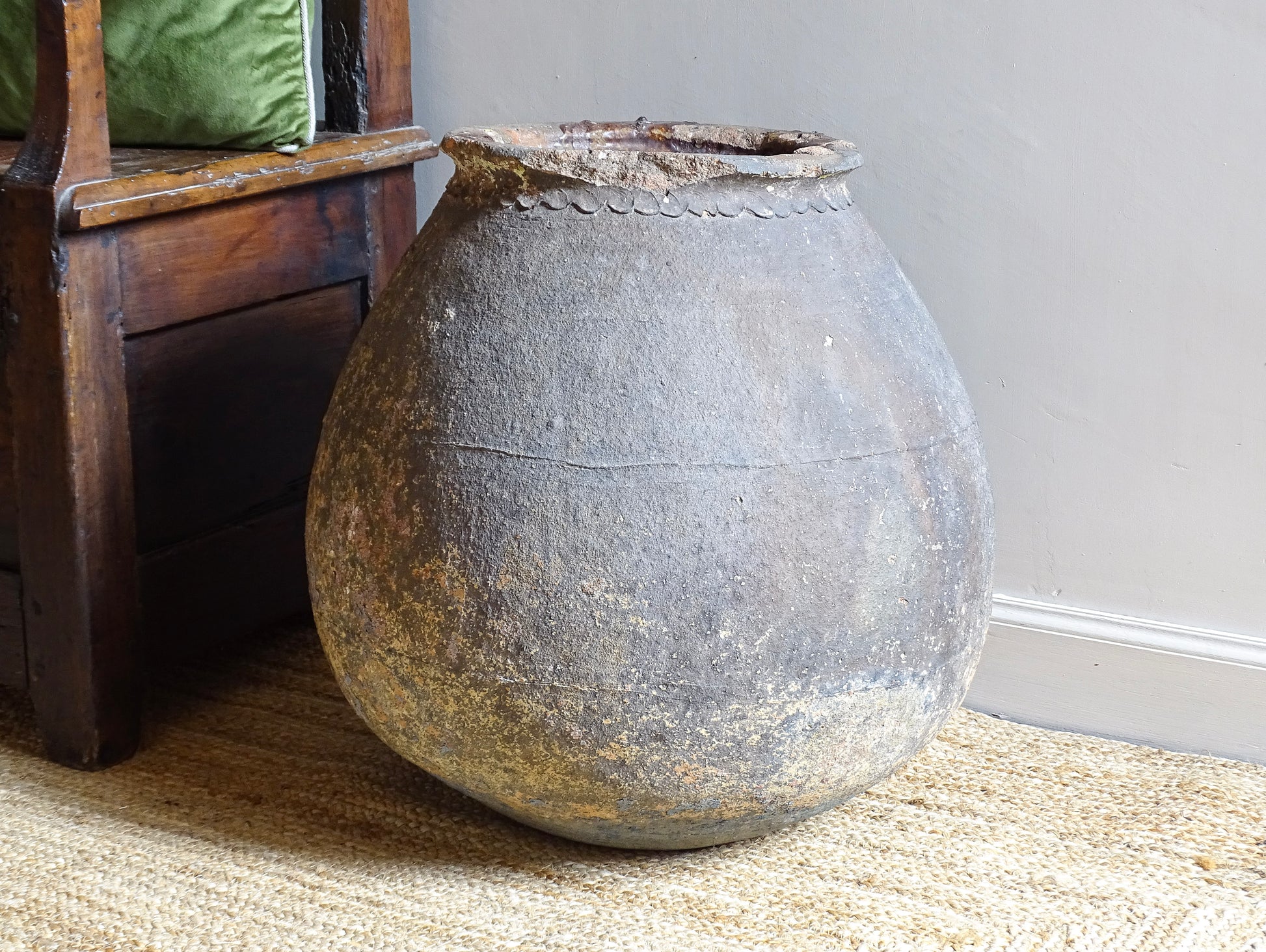 A large, early 19th century French antique terracotta pot, known as a ponne (salting pot), sourced in the Bordeaux region and likely Charentais in origin. This example has a beautifully rounded, generous form with a rolled rim. The surface is particularly special, showing layers of time, wear and historic pigment. Traces of faded blue and earthy tones remain across the body, creating a richly textured patina. 