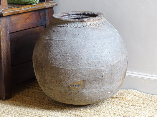 A large early 19th century French antique terracotta pot, known as a ponne (salting pot), sourced in the Bordeaux region and likely Charentais in origin.
 It has a particularly sculptural form, with a rounded body rising to a thick rolled rim and a simple incised band beneath the shoulder. The surface has developed a beautifully weathered patina over time, with areas of natural wear.