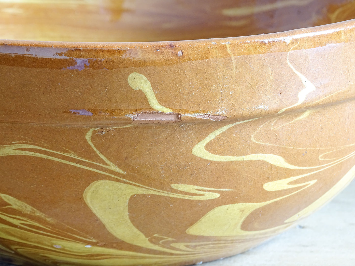 Close up of a traditional French jaspe glazed earthenware bowl with marbled yellow slip