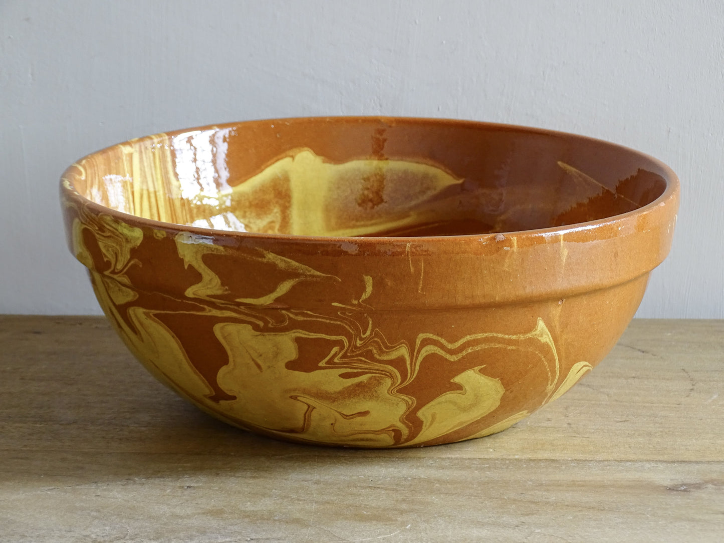 French antique pottery bowl with swirling jaspe slip decoration on terracotta