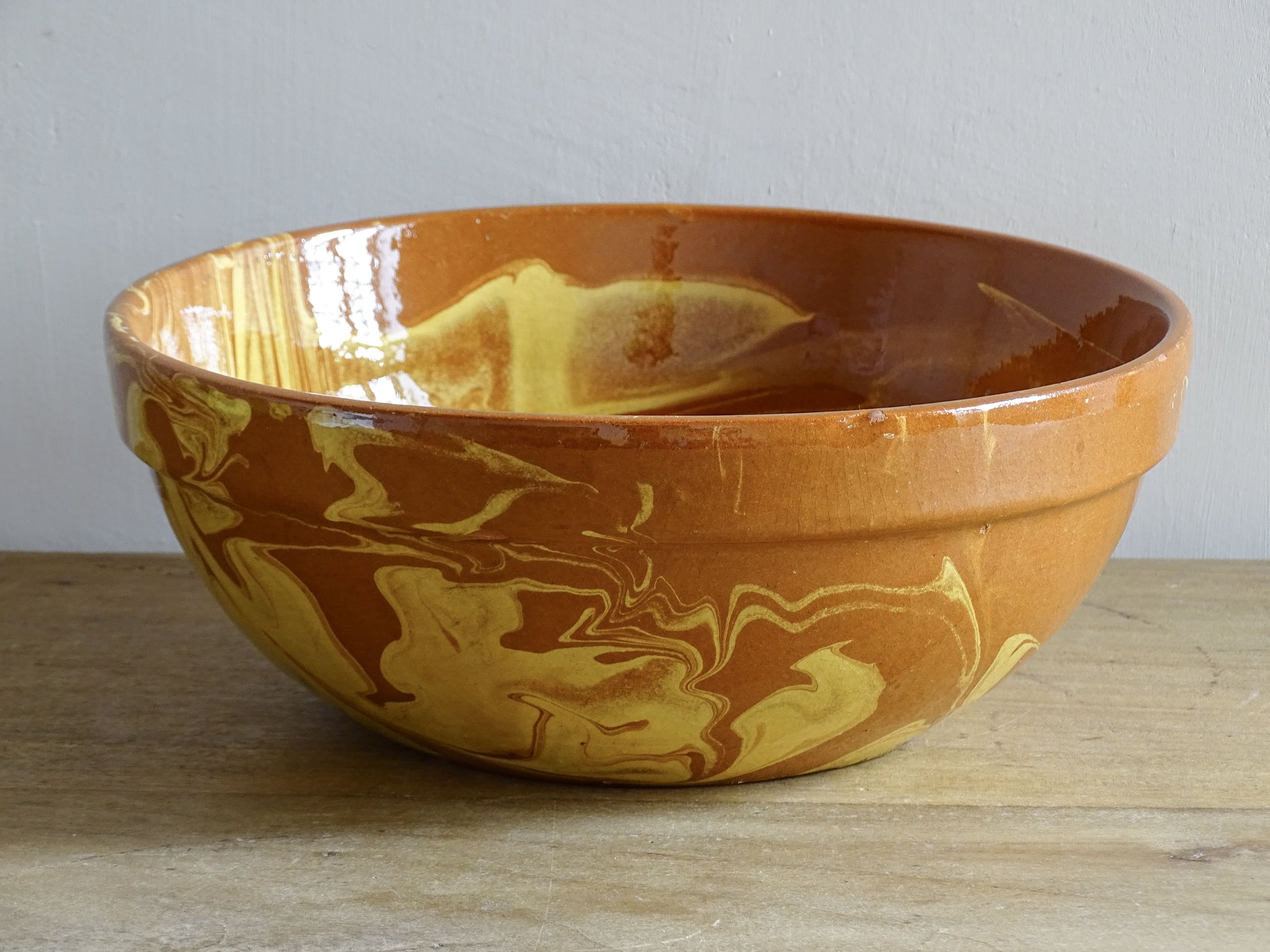 French antique pottery bowl with swirling jaspe slip decoration on terracotta