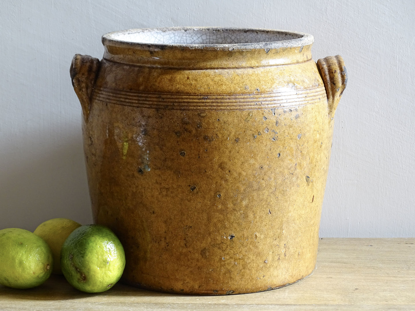 Antique French pottery jar with handles and a heavy patina for a rustic country kitchen decor.