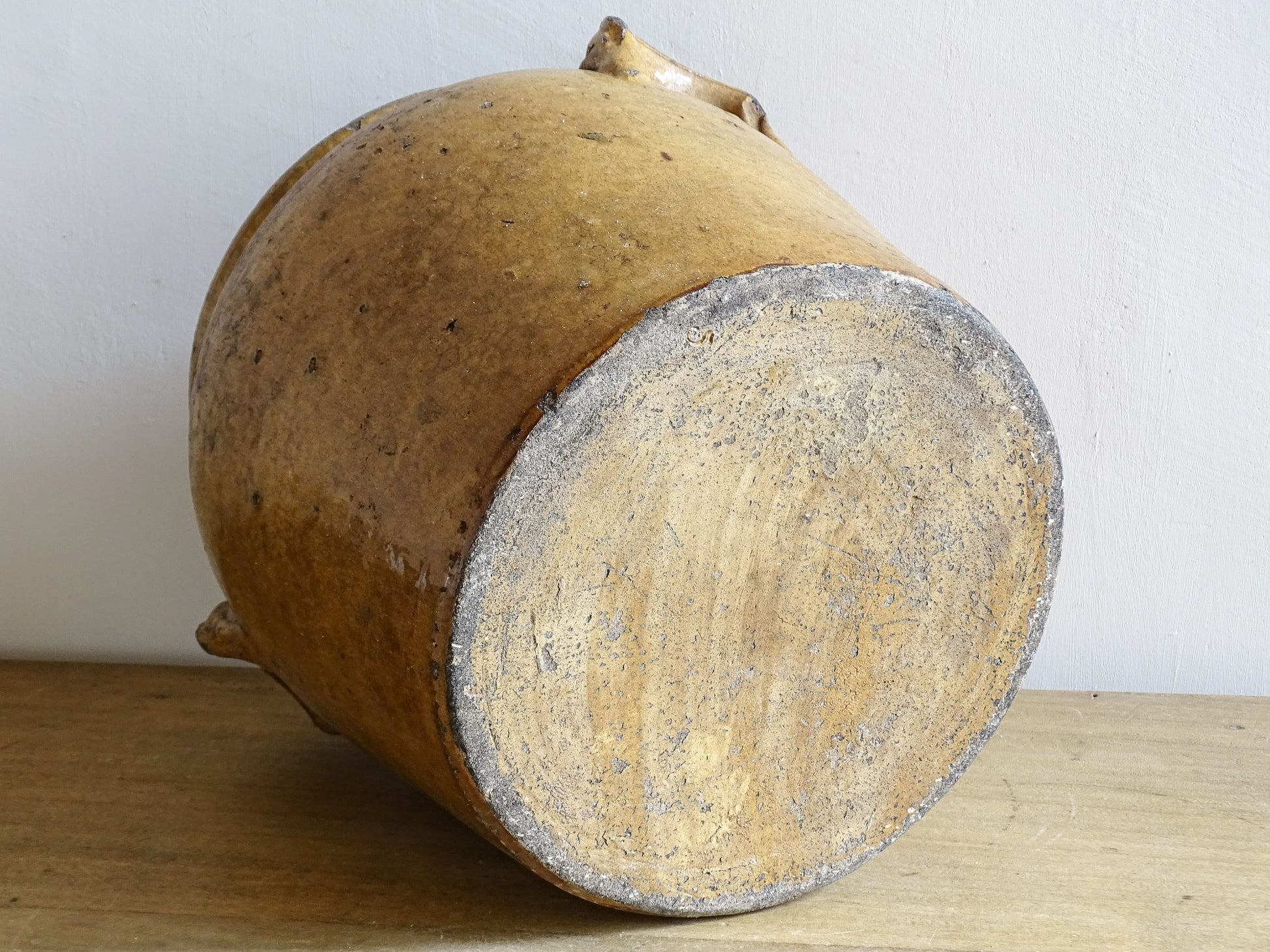 Vintage ceramic jar with a textured surface on a wooden surface