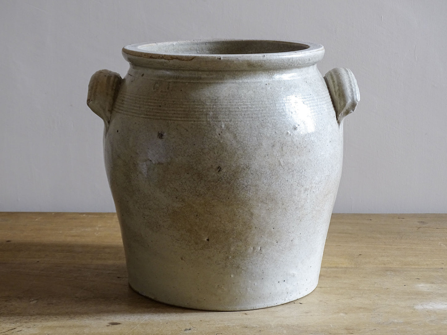 Antique French confit pot with a beige glaze in stoneware.