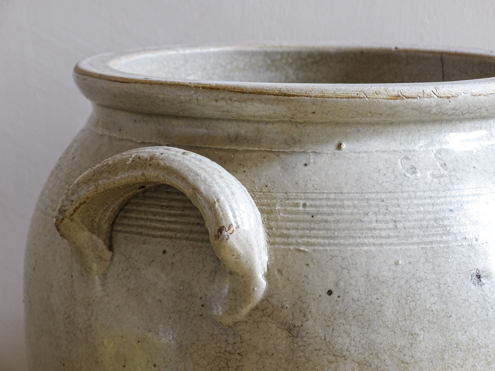Close up of the handle of a French antique stoneware jar or confit pot