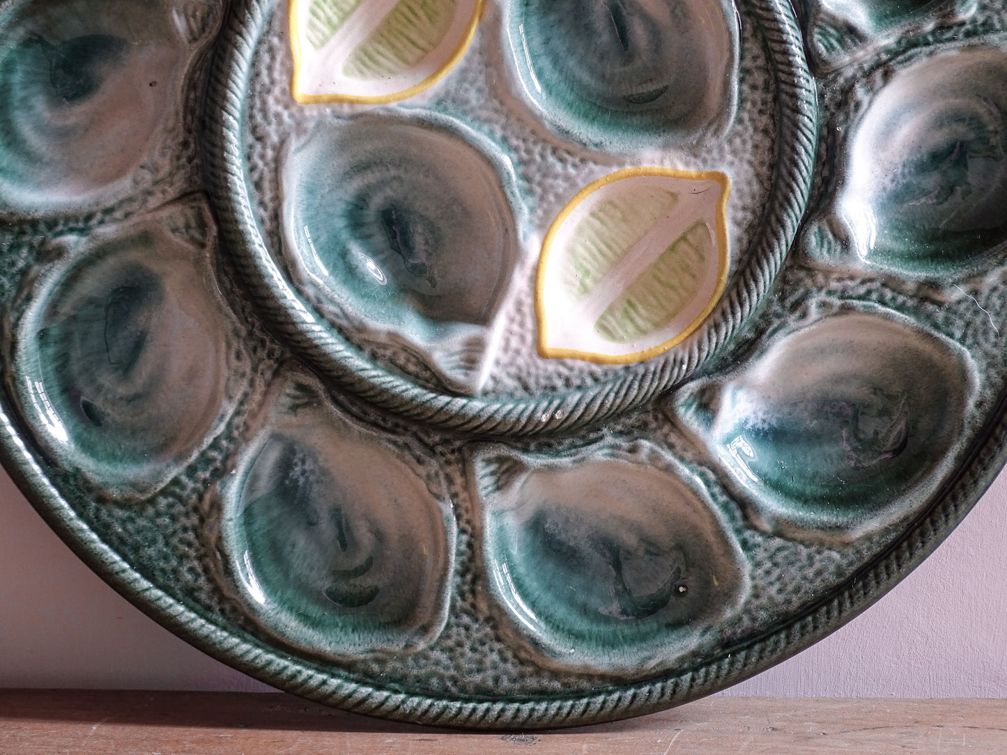 Vintage French oyster platter with twelve oyster compartments arranged around a central serving well.