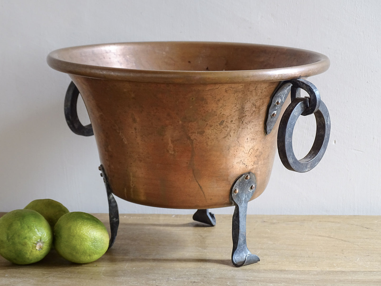 Vintage French copper planter with wrought iron ring handles and three forged iron feet.