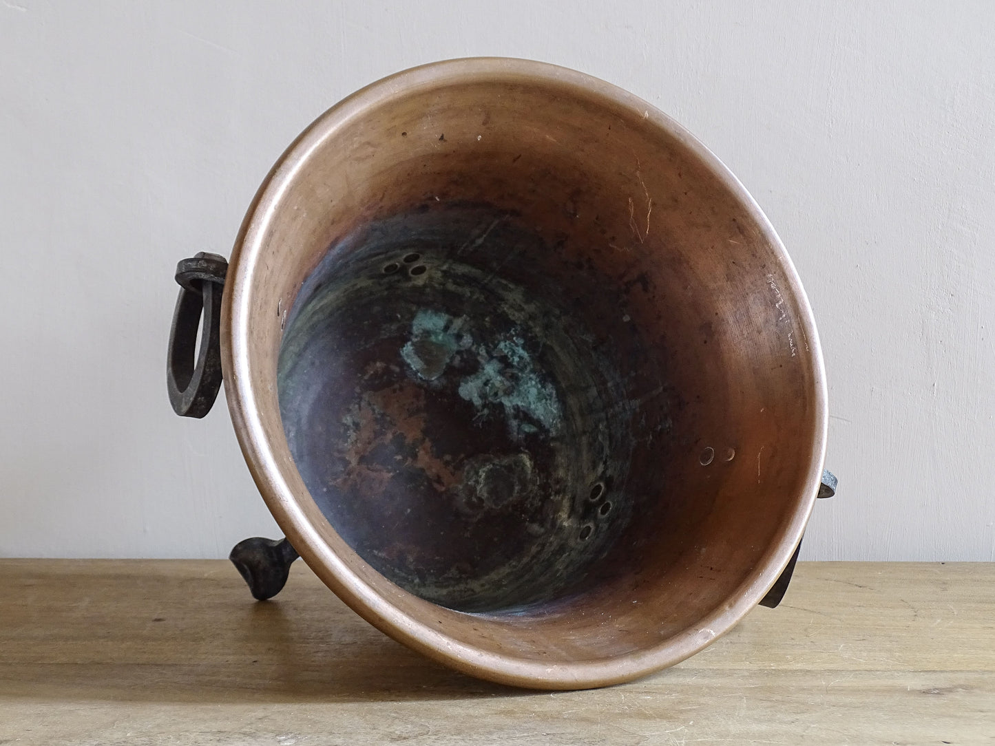 Vintage copper planter with forged iron ring handles and three decorative iron legs.