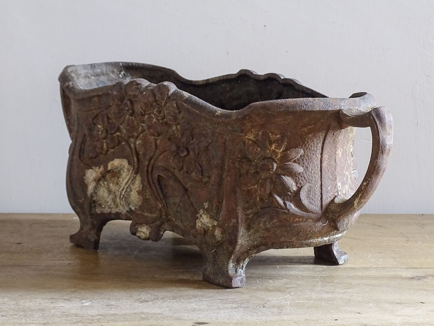 Art Nouveau cast iron planter from France with sculpted flowers and decorative handles.
