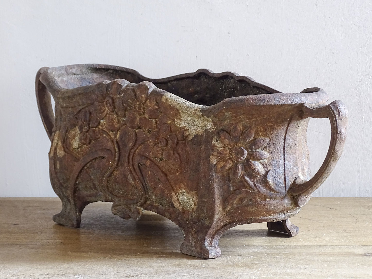 Antique Art Nouveau jardinière with flowing lines and floral design in cast iron.