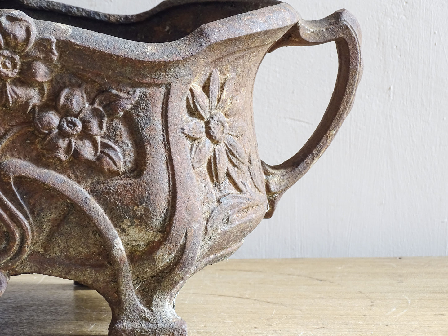 Antique French cast iron jardinière with Art Nouveau floral motifs and curved feet.