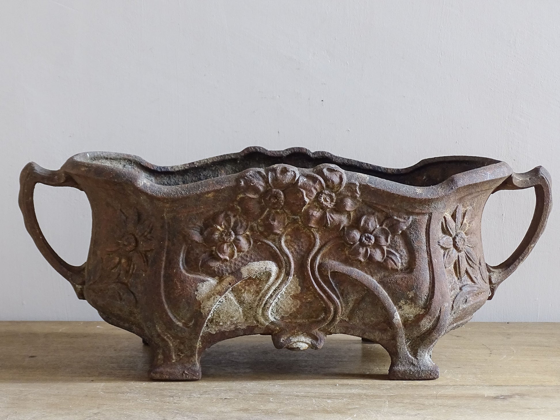 French antique cast iron garden planter with ornate floral relief decoration.