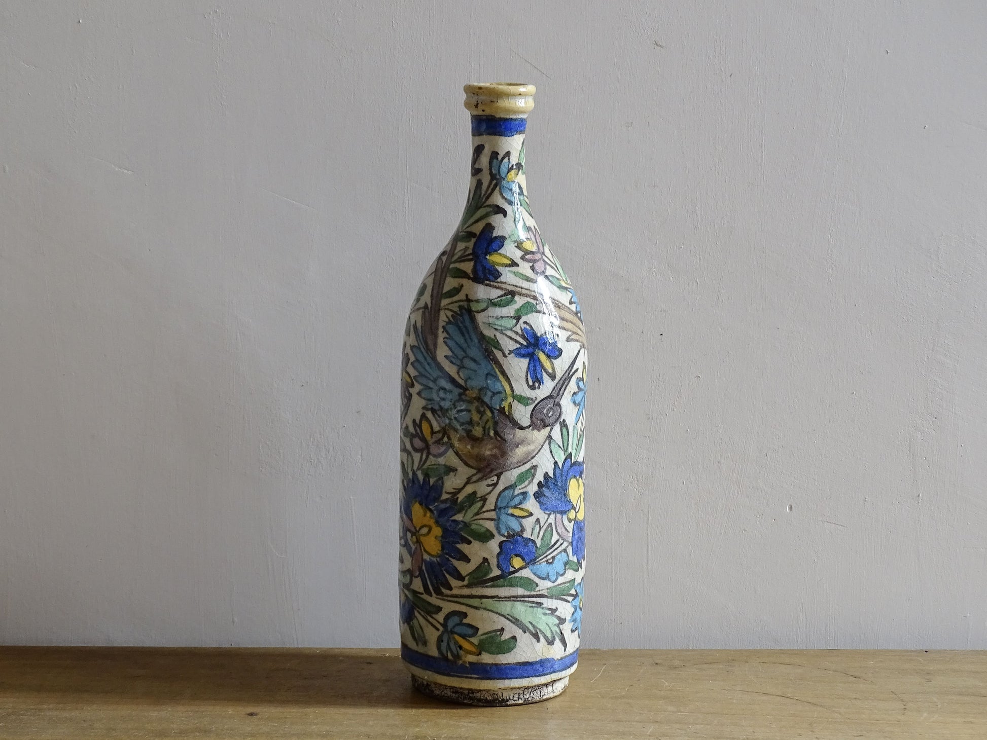 Antique Middle Eastern ceramic vase with birds and blue floral decoration.