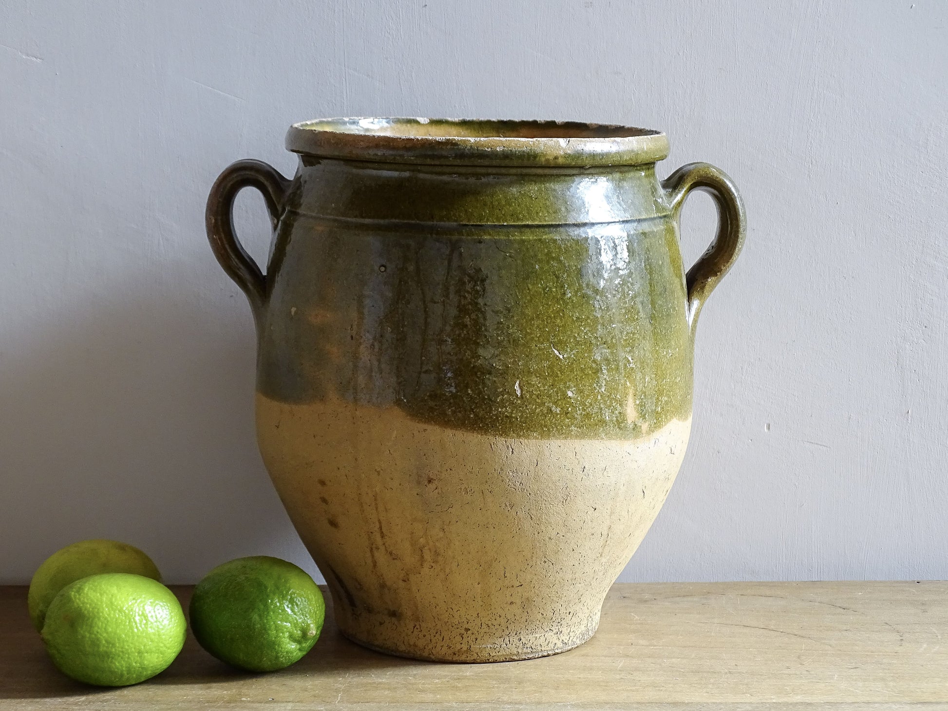 Antique French confit pot with olive green glaze and rustic clay base