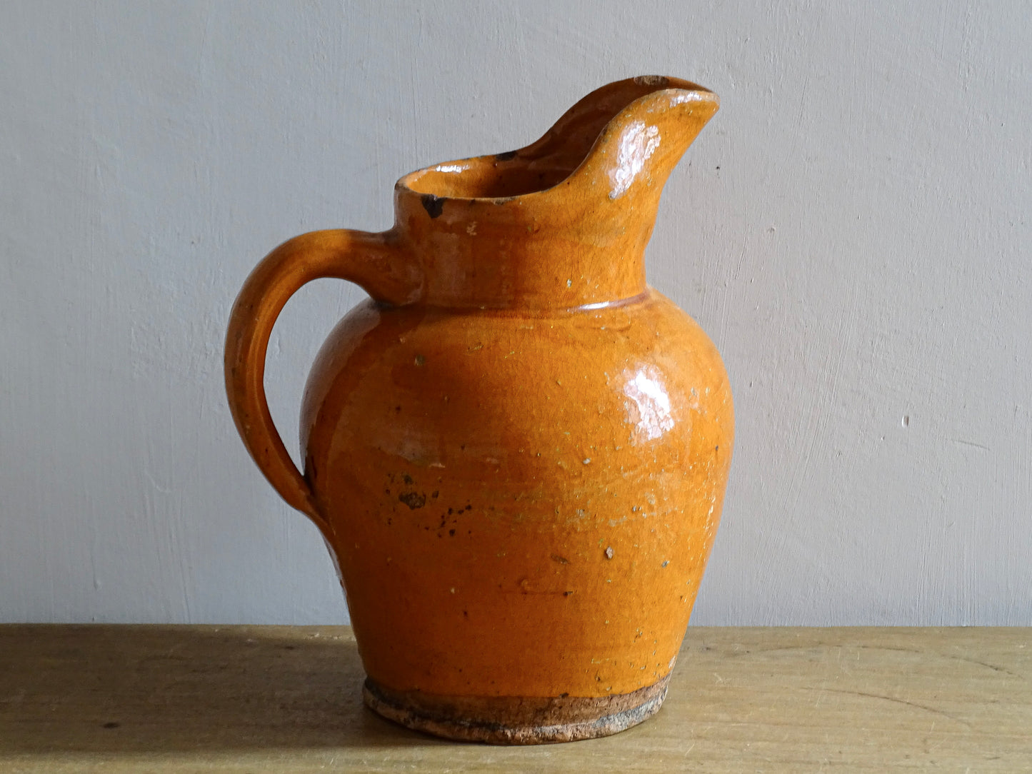 Antique French water pitcher with warm orange glazed ceramic body