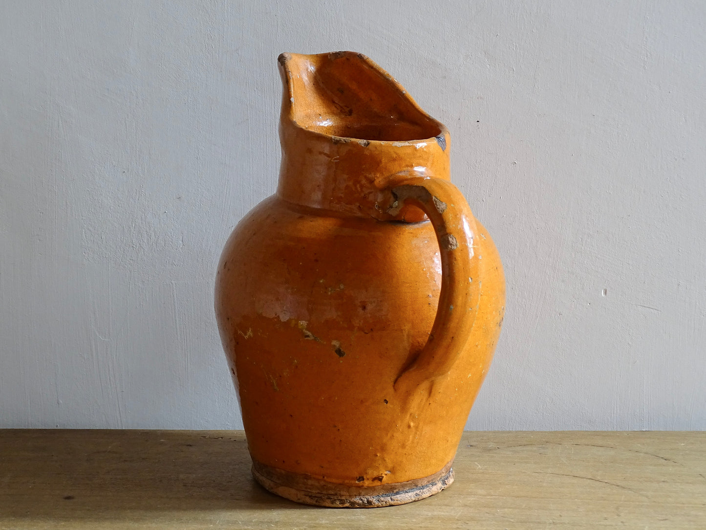 Rustic French antique pottery pitcher with orange glaze