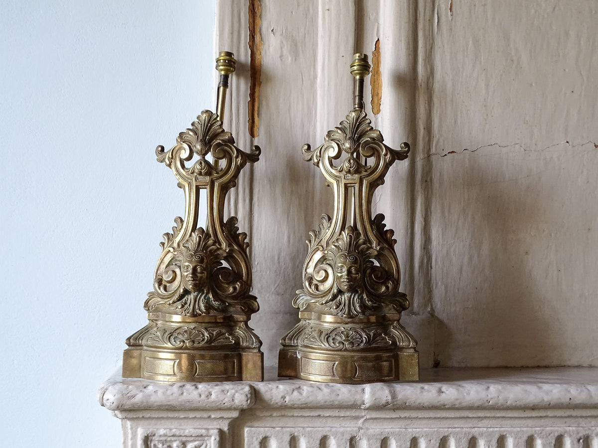 French antique brass andirons as table lamps, displayed on a country house fireplace