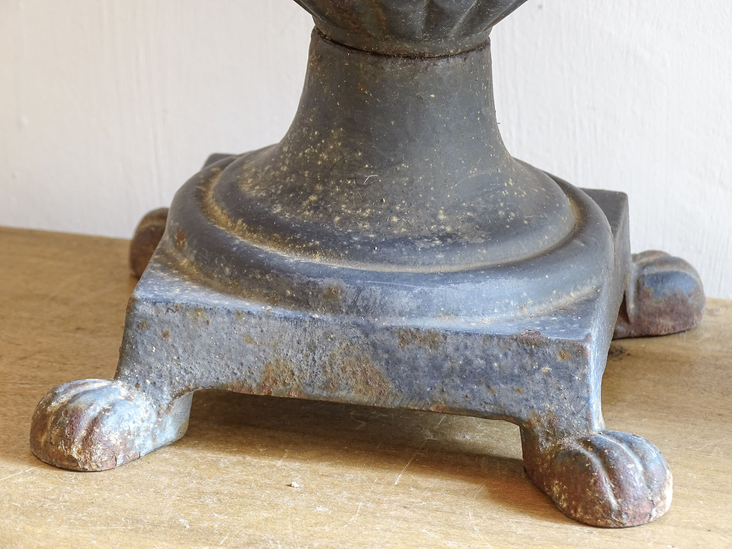 A sculptural pair of French antique cast iron urn planters, with fluted bowls set on stepped bases and raised on paw feet. These antique planters date to to the latter part of the 19th century. They have developed a deep, dark patina.
