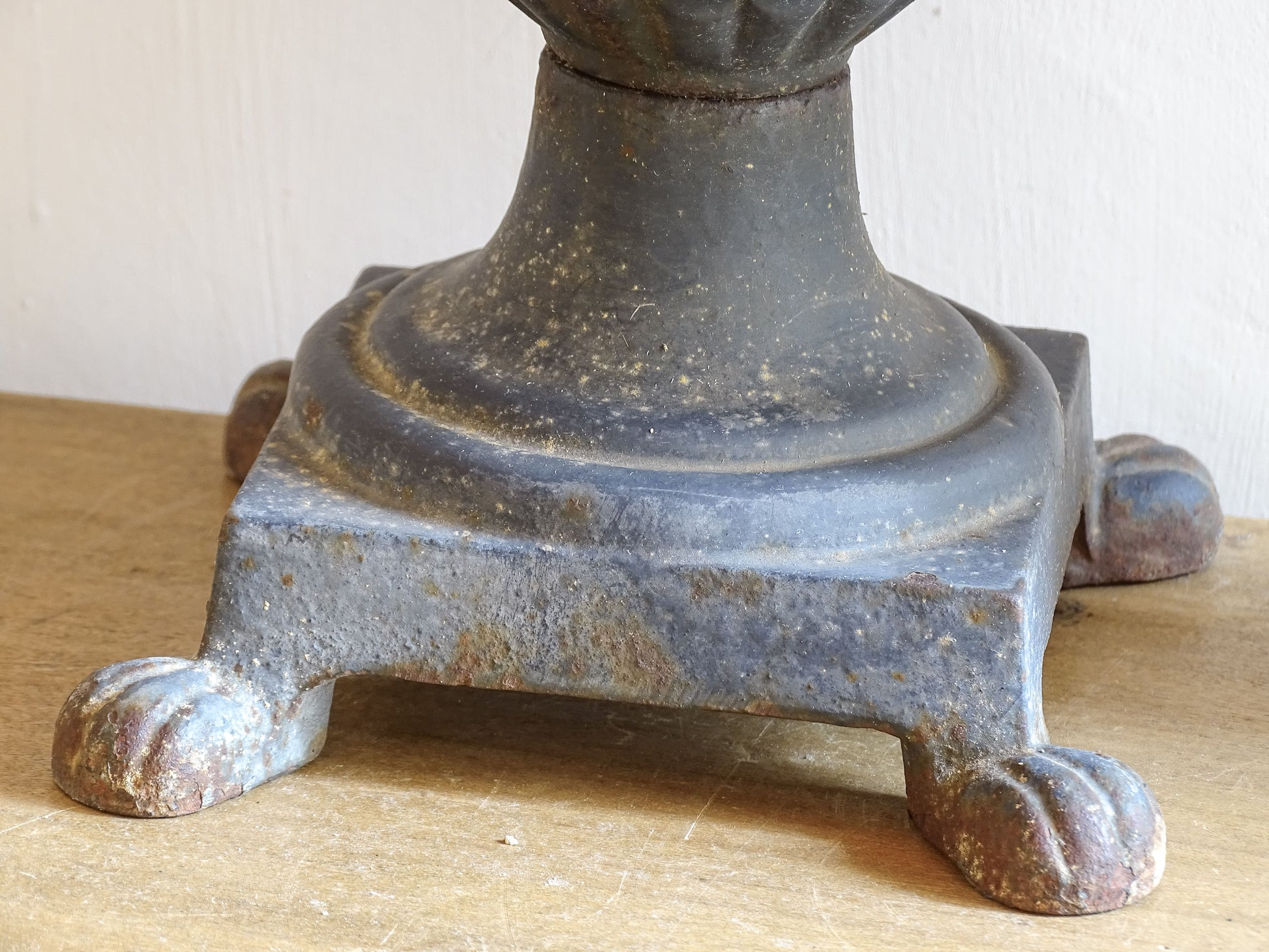 A sculptural pair of French antique cast iron urn planters, with fluted bowls set on stepped bases and raised on paw feet. These antique planters date to to the latter part of the 19th century. They have developed a deep, dark patina.